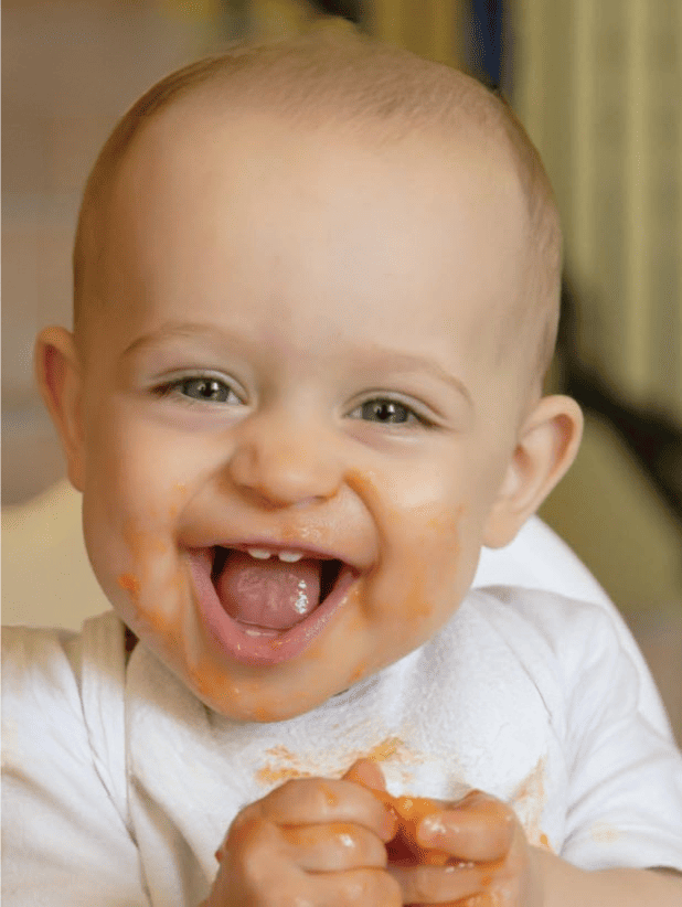 A happy baby eating finger foods