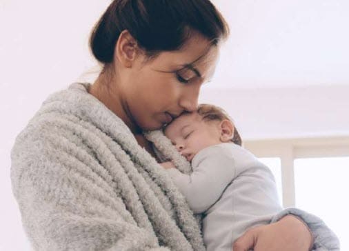 A woman kissing a baby