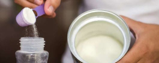 A person making powdered infant formula