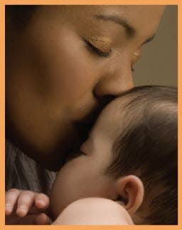 A woman kissing a baby