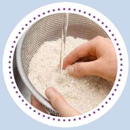 A person rinsing out rice in a collander