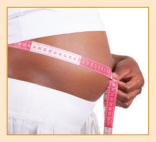 A pregnant woman measuring her belly