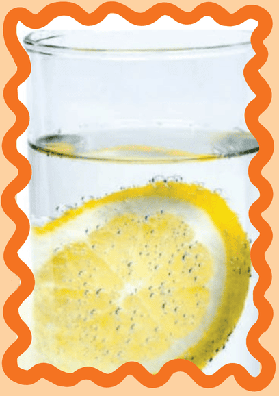Glass of water with a lemon slice in it.