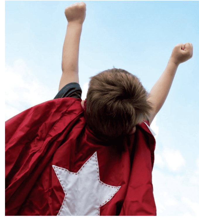 A little child with a cape on that has a star on it