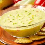 Corn chowder in a bowl with crackers on the side