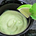Creamy Vegan Avocado Salad Dressing in a bowl with a slice of lime