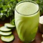 Green Power Protein Smoothie in a glass with cucumbers on the side