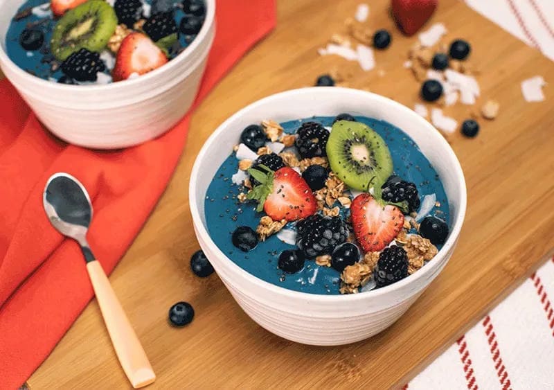 Tropical Blue Smoothie Bowl with berries and kiwi in a bowl