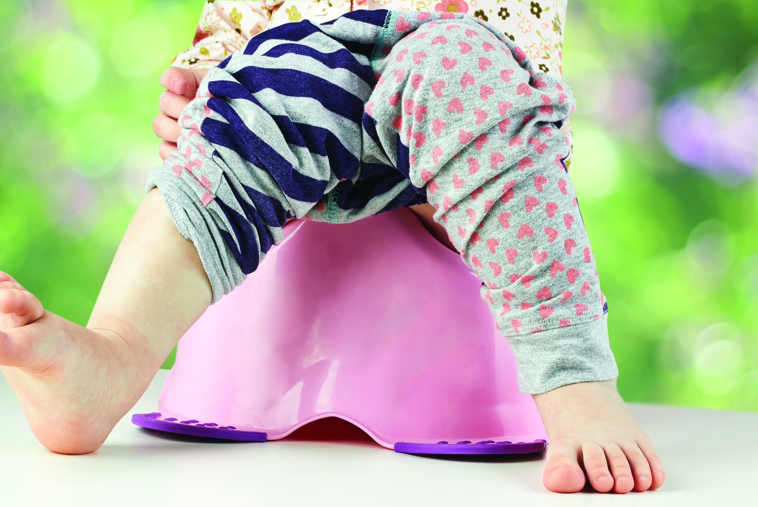 Child sitting on a pink potty