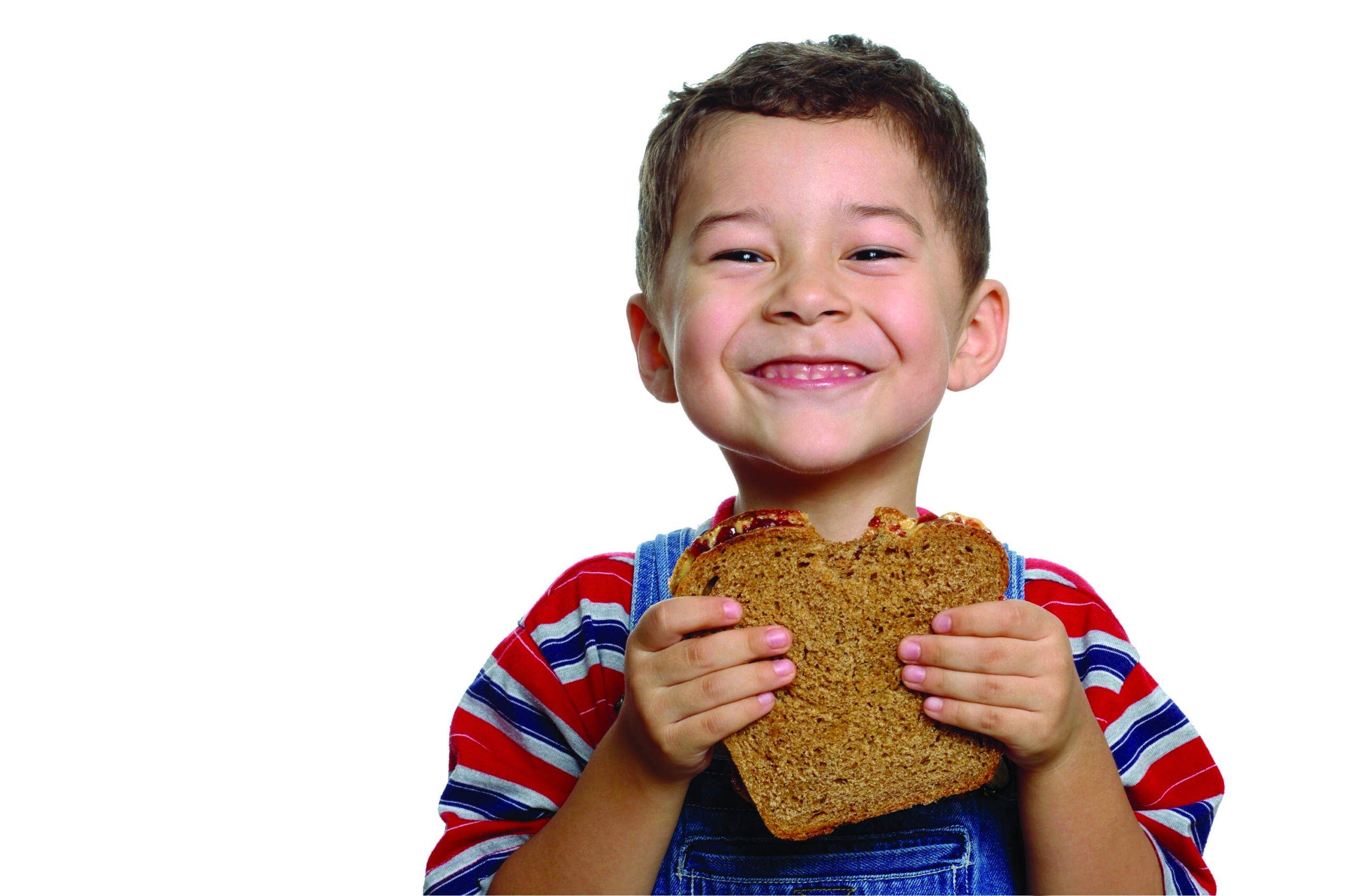A smiling boy eating a sandwich